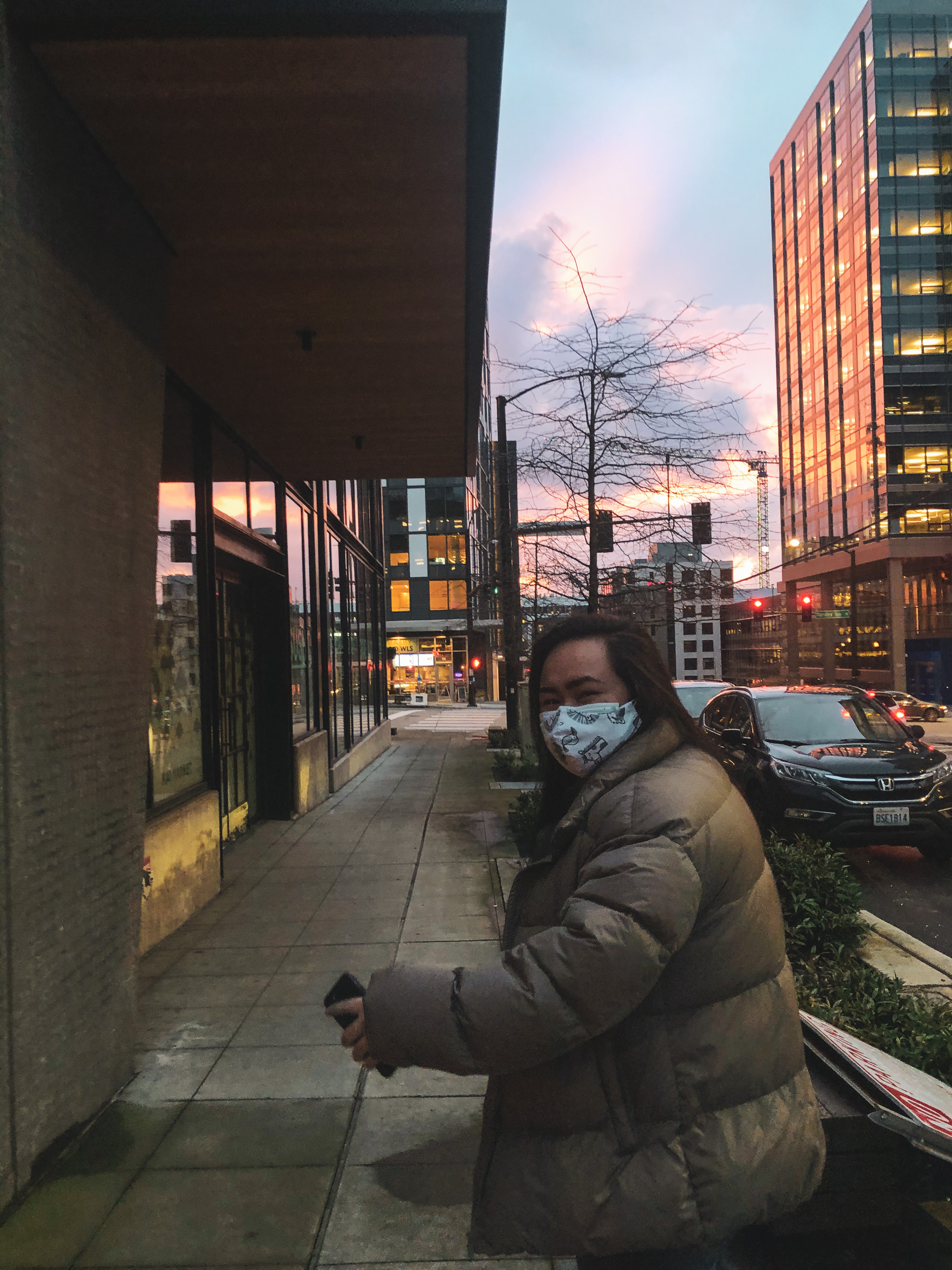 photo of Danica wearing a mask and walking through a Seattle sunset.